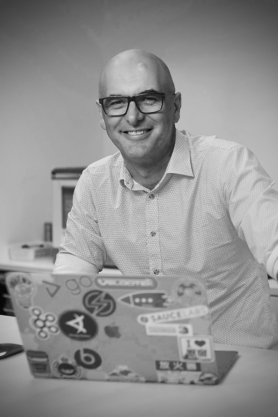 Bruce McLeod Sitting behind a laptop at a desk